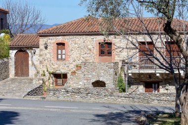 Manzara. Güneşli bir bahar gününde dağlık bir kırsaldaki eski taştan ev (Yunanistan, Mora)).