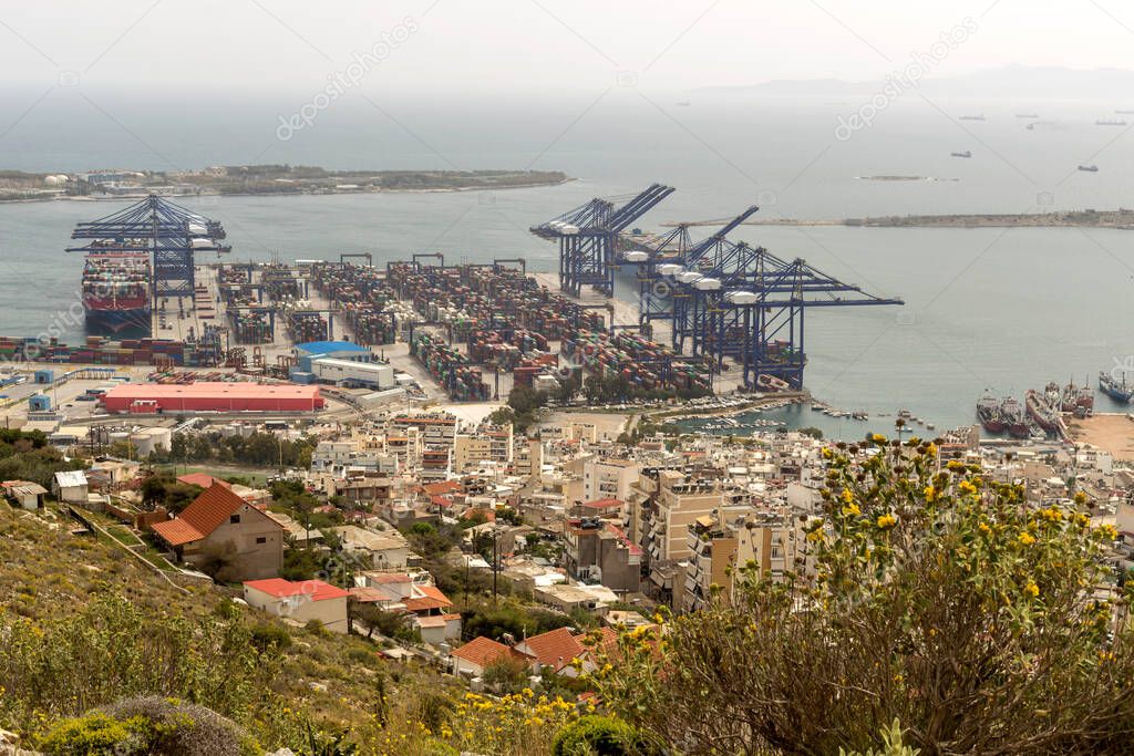 Panoramic view of the port of Perama region (Greece), cranes, houses and the sea from high on a cloudy, spring day