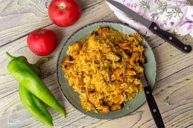 Deniz ürünleri. Ahşap bir masa üzerinde baharatlı midyelerden elde edilen pilav.