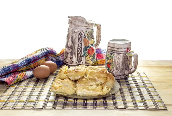Слой торт с сыром, кувшин и чашка молока на столе крупным планом. Греческая кухня — стоковое фото