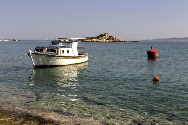 Een oude vissersboot op de achtergrond van de zee is afgemeerd offshore — Stockfoto