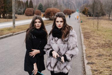 Sonbahar parkta bir tablet ile iki güzel kız