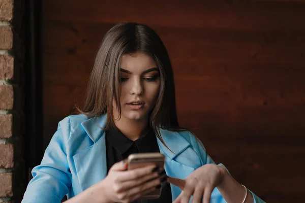 Happy young lady working with smartphone and smiling — Stock Photo, Image