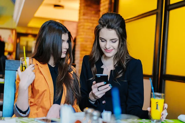 Two beautiful girls in cafes phones — Stock Photo, Image