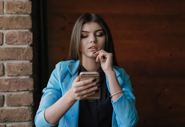 Happy young lady working with smartphone and smiling — Stock Photo, Image