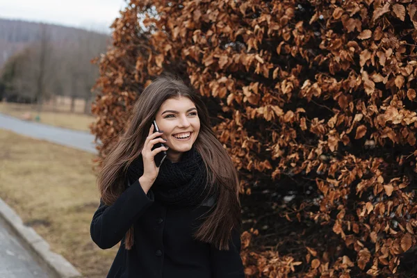 Schönes Mädchen mit Handy im Park — Stockfoto