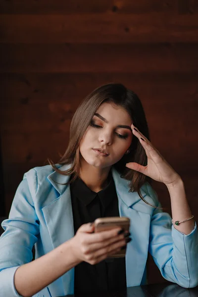 Happy young lady working with smartphone and smiling — Stock Photo, Image