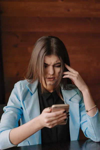 Happy young lady working with smartphone and smiling — Stock Photo, Image