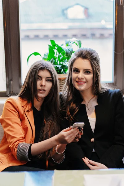 Dos hermosas chicas en cafés teléfonos —  Fotos de Stock