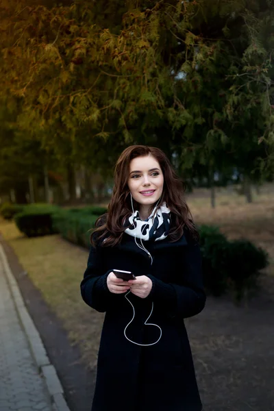 Hermosa chica escucha música en el parque —  Fotos de Stock