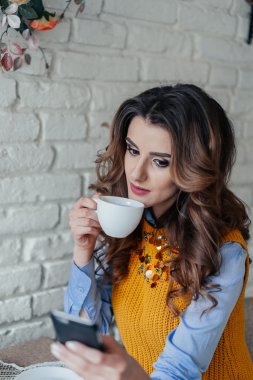 Çay içme ve telefon ile çalışma güzel kız