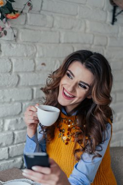 Çay içme ve telefon ile çalışma güzel kız