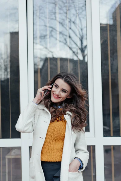 Hermosa chica con un teléfono en la ciudad —  Fotos de Stock