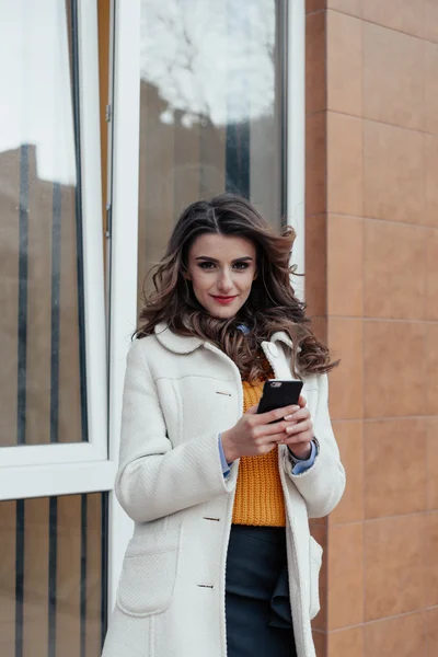 Hermosa chica con un teléfono en la ciudad —  Fotos de Stock