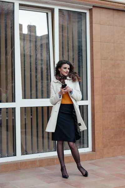 Vacker flicka med en telefon i stan — Stockfoto