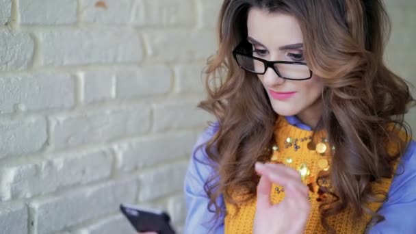 Retrato de la señora de estilo usando el teléfono inteligente y preguntándose en la cafetería — Vídeos de Stock