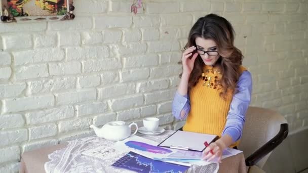 Mulher de negócios em óculos trabalhando com documentos no café — Vídeo de Stock