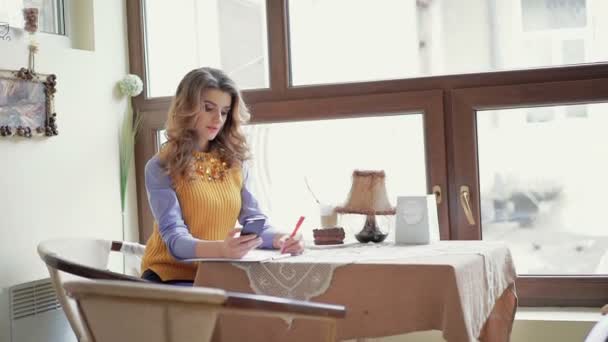 Chic mulher de negócios escrevendo, usando telefone na mesa no café — Vídeo de Stock