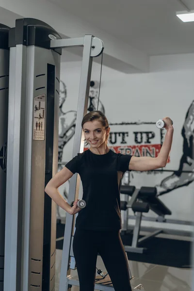 Hermosa chica en el gimnasio con pesas — Foto de Stock