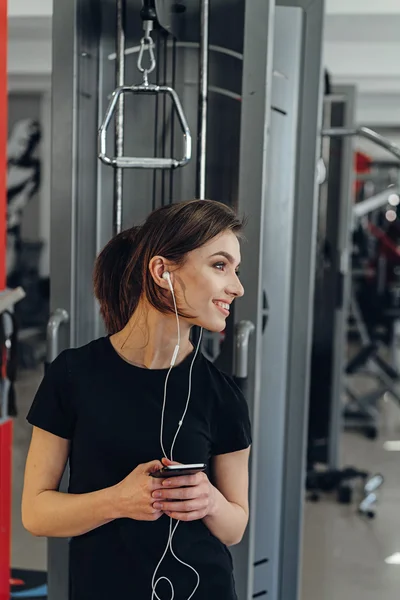 Chica con auriculares en el gimnasio — Foto de Stock