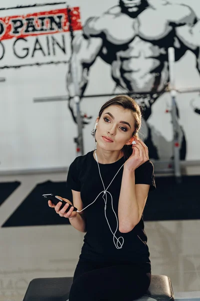 Chica con auriculares en el gimnasio — Foto de Stock