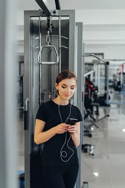 Chica con auriculares en el gimnasio — Foto de Stock