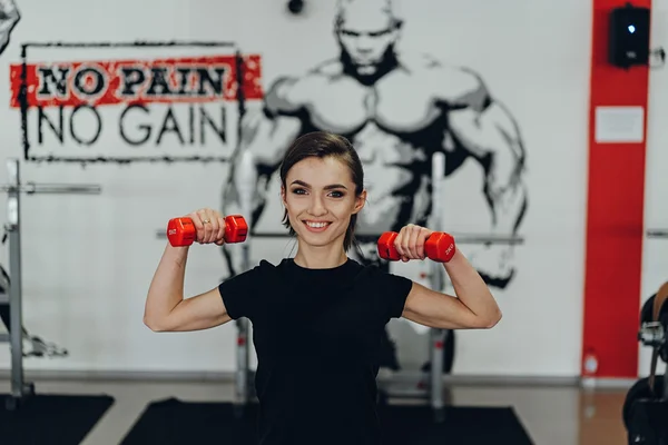 Hermosa chica en el gimnasio con pesas — Foto de Stock