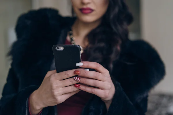 Elegantes Modell in schwarzem Mantel mit Telefon — Stockfoto