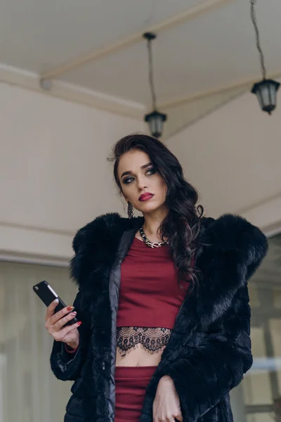Elegancki model w czarny płaszcz z telefonu — Zdjęcie stockowe