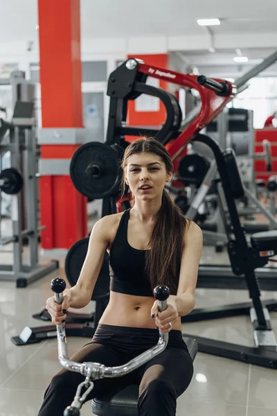 Kız egzersizleri simülatörü üzerinde gerçekleştirir.