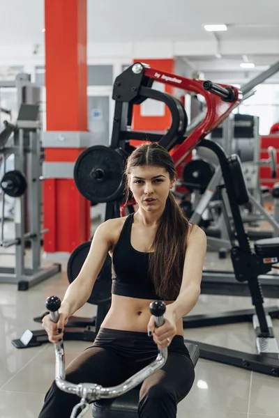 Chica realiza ejercicios en el simulador — Foto de Stock