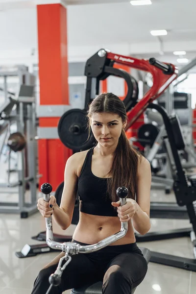 Chica realiza ejercicios en el simulador — Foto de Stock