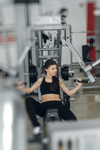Chica realiza ejercicios en el simulador — Foto de Stock