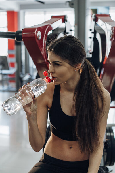 Beautiful girl with water at the gym