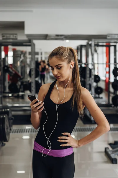 Rubia escuchando música en el gimnasio — Foto de Stock