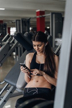 Spor salonunda bir telefon ile güzel kız
