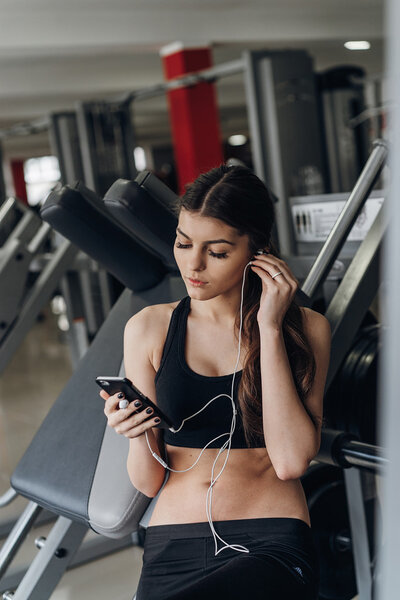 Beautiful girl with a phone in the gym