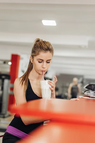 Belle blonde dans la salle de gym boire des protéines — Photo