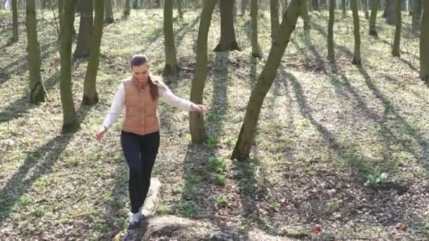 Une jeune fille va sur un arbre qui est tombé. 4k — Video