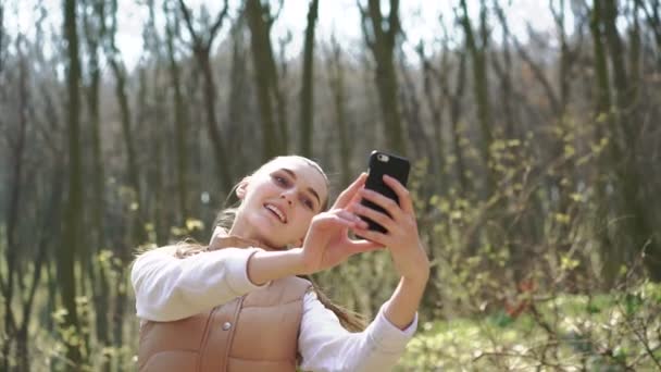 La chica hace una selfie en el parque. 4k — Vídeos de Stock