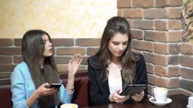Kafede oturan kızlar smartphone ile haber paylaşımı