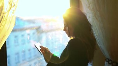 Çekici kız tablet, kullanma pencereden bakıyor