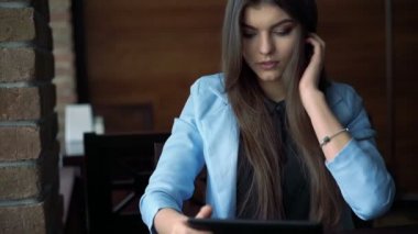 Şirin esmer kafede otururken, gülümseyen ve telefon kullanma