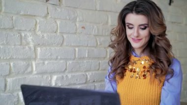 Bayan kafede dizüstü bilgisayar ile çalışma ve gülümseyen office tarzda