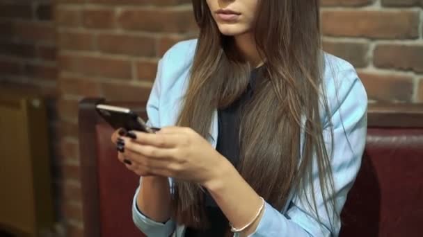 Ragazza carina guardando il telefono e ridendo in caffè — Video Stock