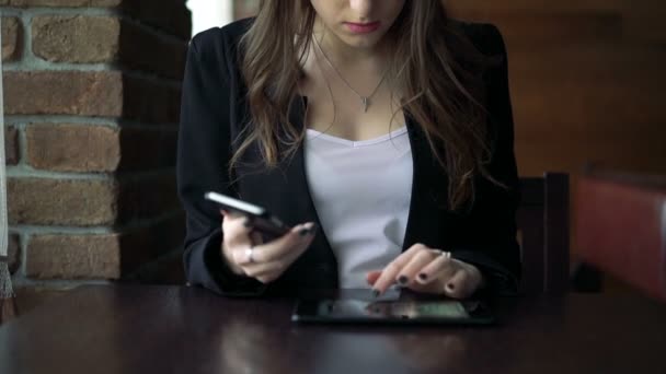 Modelo sentado en la cafetería y hablando por teléfono — Vídeos de Stock