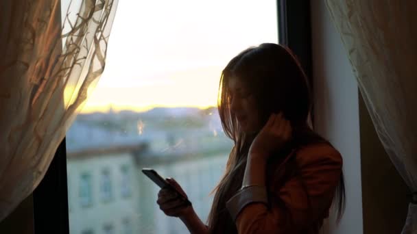 Charmantes Mädchen blickt aus dem Fenster und bewundert. — Stockvideo