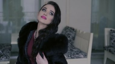 Pahalı kürk zarif Bayan kameraya poz veriyor ve gülümseyerek. 4k