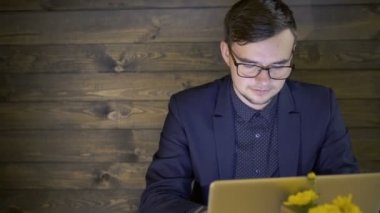 Dizüstü bilgisayar ve telefon kafede çalışan iş adamı