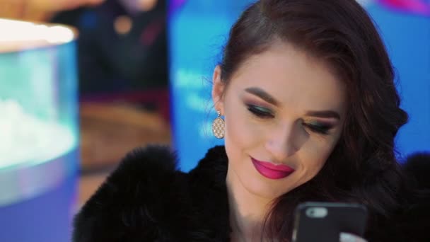 Chica encantadora con maquillaje brillante usando el teléfono. Despacio. — Vídeos de Stock